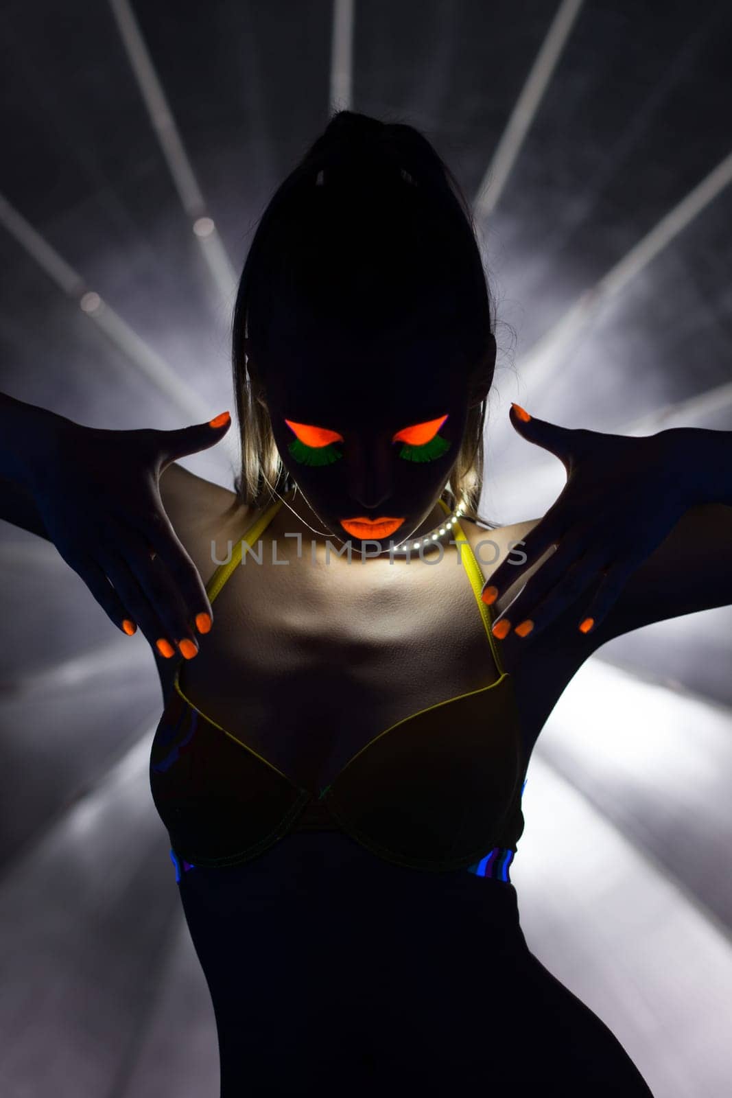 Image of silhouette of slender girl with UV makeup, close-up