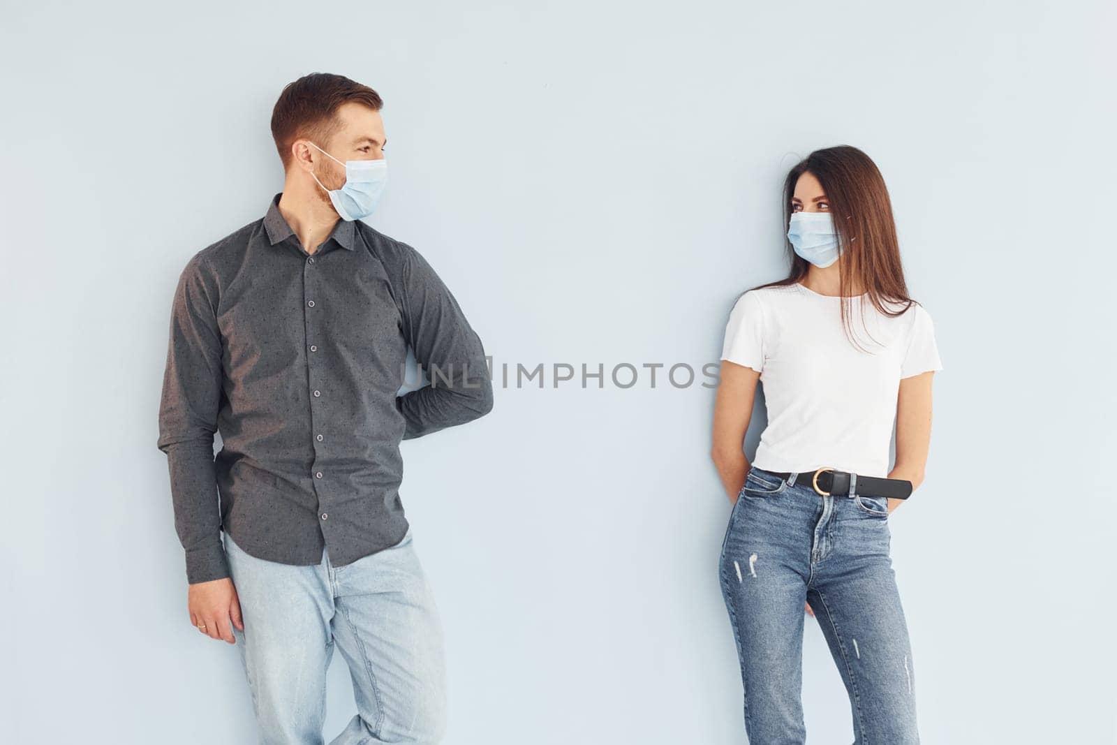 Man and woman standing indoors in the studio against white background by Standret