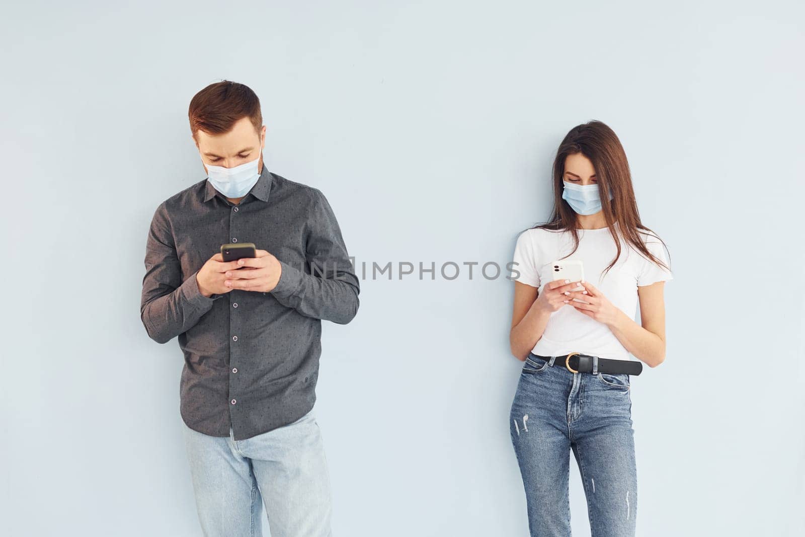 Man and woman standing indoors in the studio against white background.