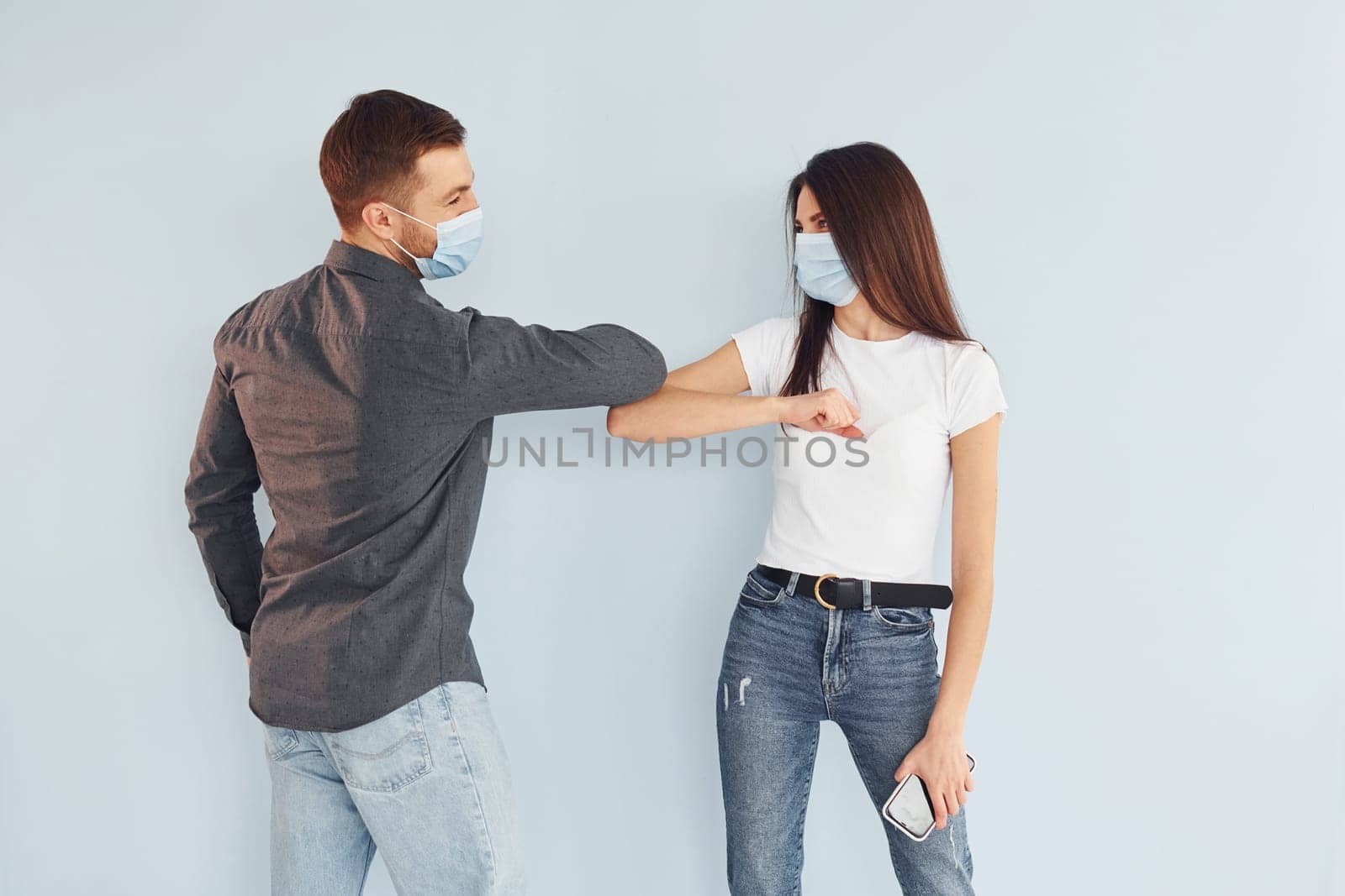 Man and woman standing indoors in the studio against white background by Standret