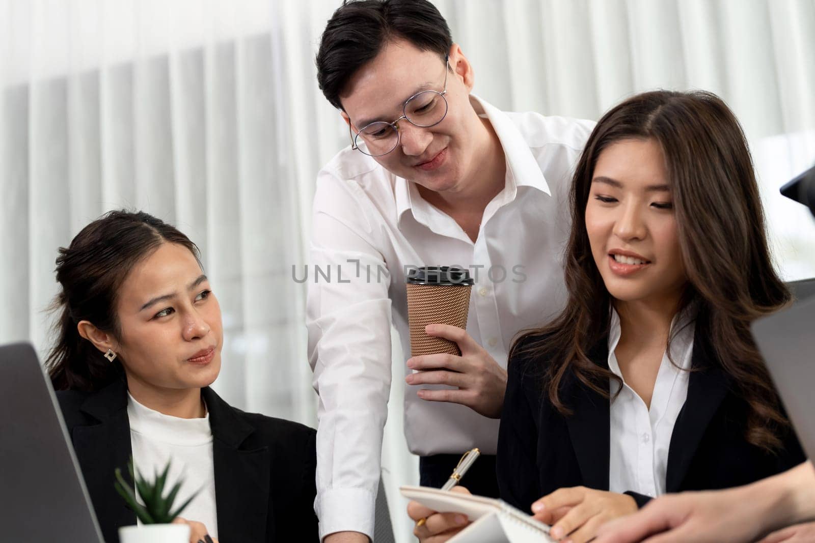 Harmony in office concept as business people analyzing dashboard paper together in workplace. Young colleagues give ideas at manager desk for discussion or strategy planning about project.