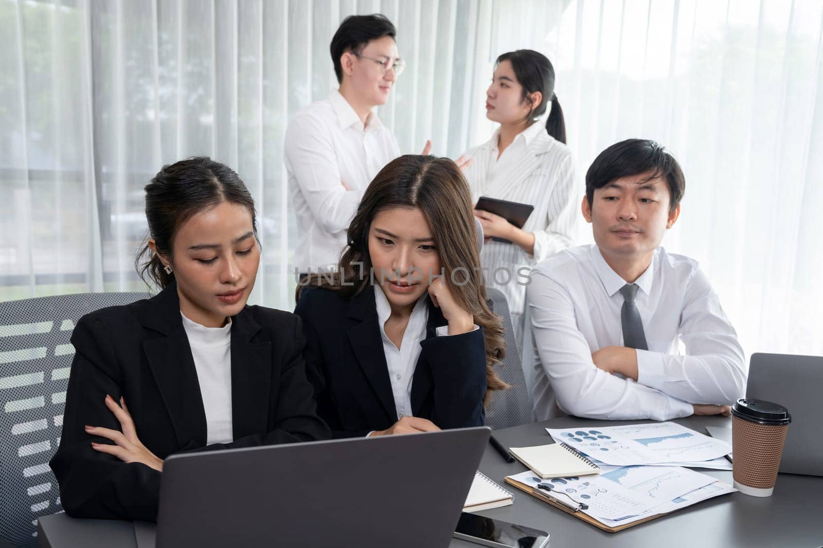 Harmony in office concept as business people analyzing dashboard paper together in workplace. Young colleagues give ideas at manager desk for discussion or strategy planning about project.