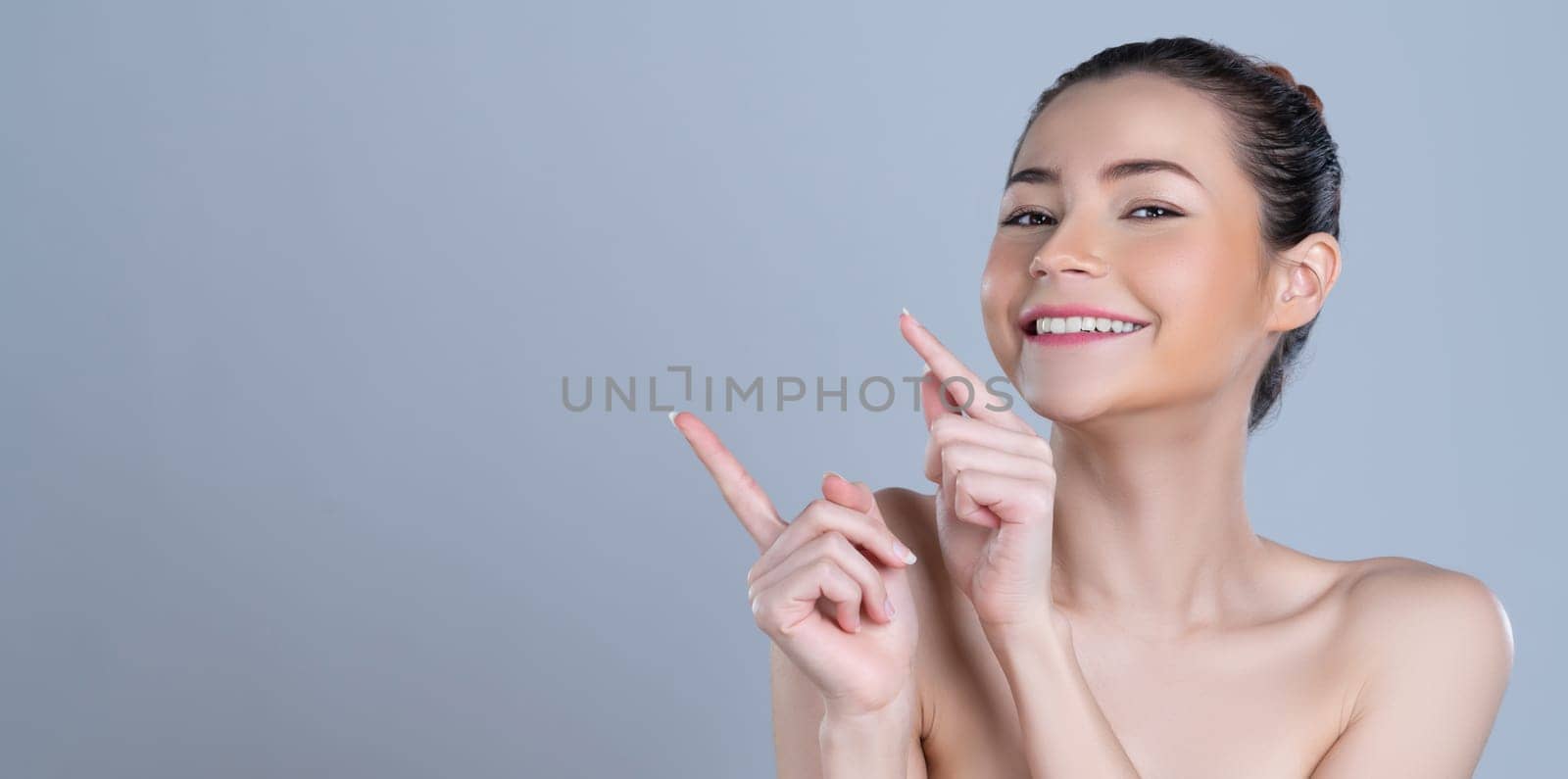 Glamorous woman pointing finger advertising product in isolated background. by biancoblue