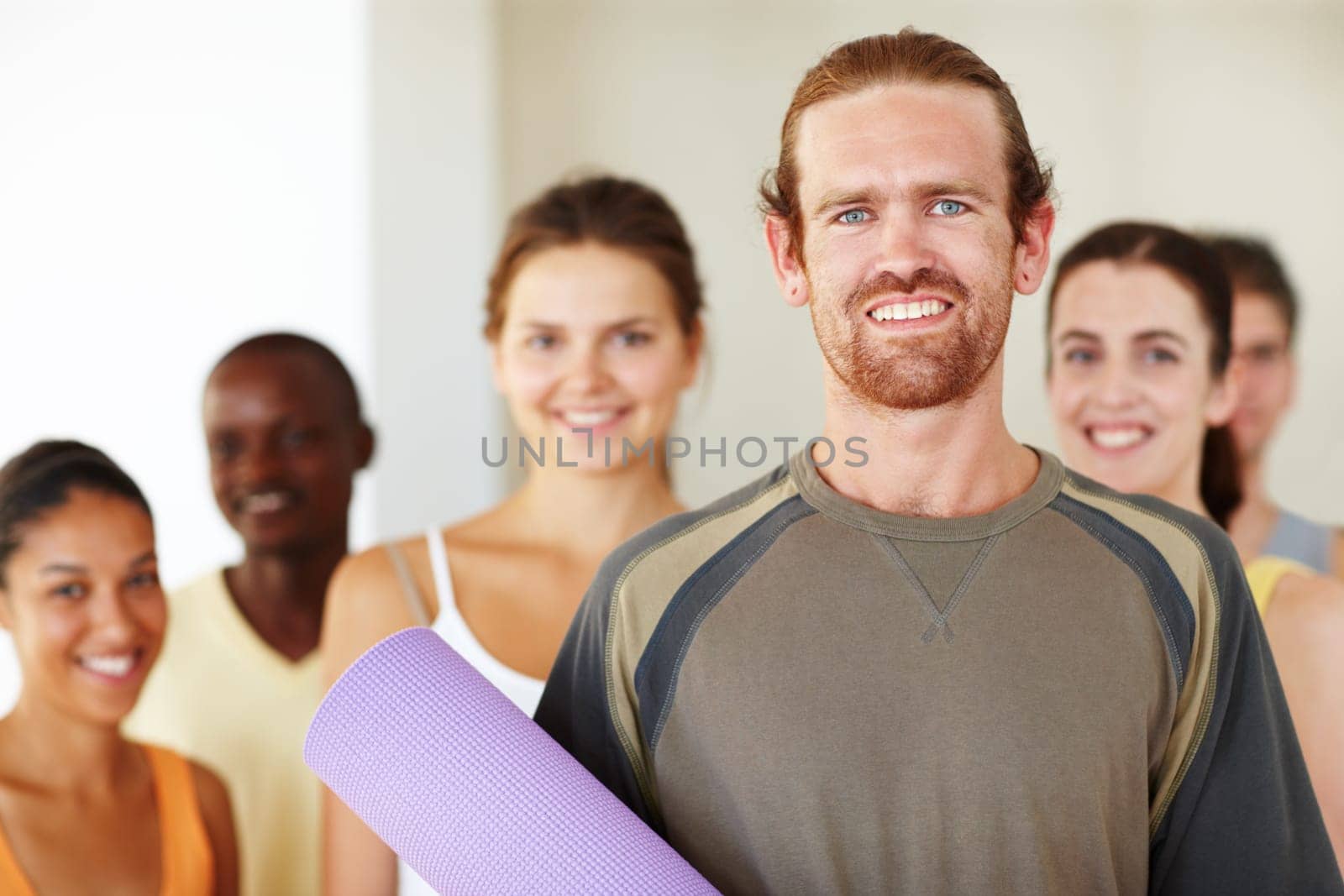 Hes glad he found yoga. Portrait of a happy group of yoga enthusiasts standing in a yoga class