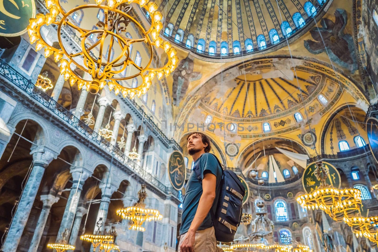 Man tourist enjoying Hagia Sofia, Ayasofya interior in Istanbul, Turkey, Byzantine architecture, city landmark and architectural world wonder. Turkiye.
