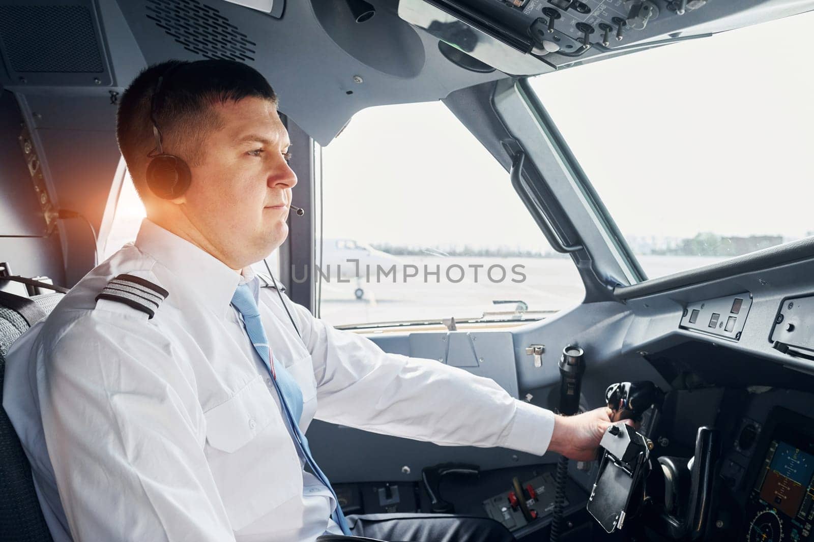 Side view. Pilot in formal wear sits in the cockpit and controls airplane.