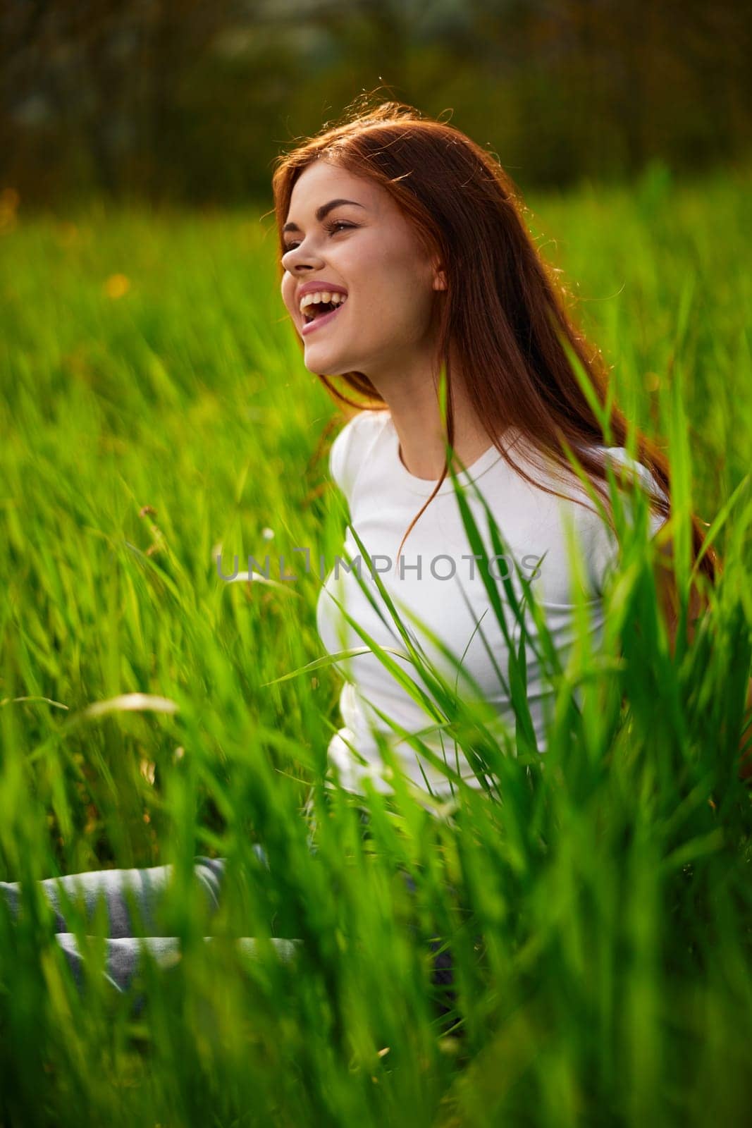 portrait of a laughing red-haired woman sitting in the grass by Vichizh