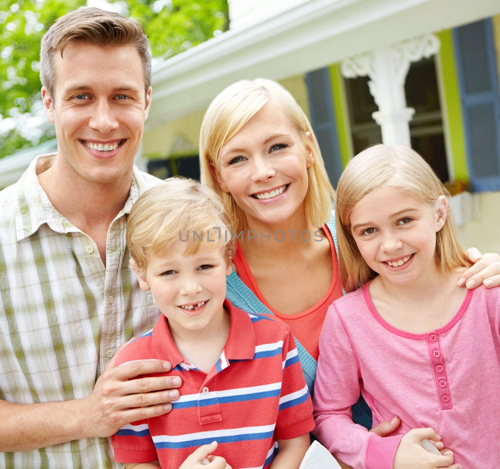 As close as family can be. a young family of four outside