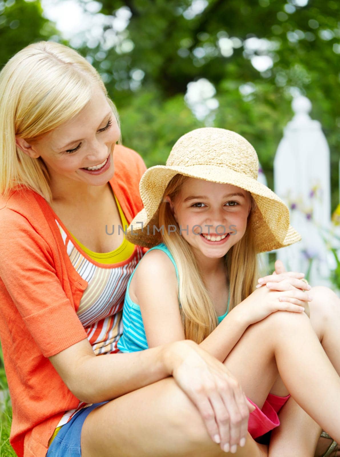 Making summer memories. Cute litte girl sitting on the grass outdoors with her mom