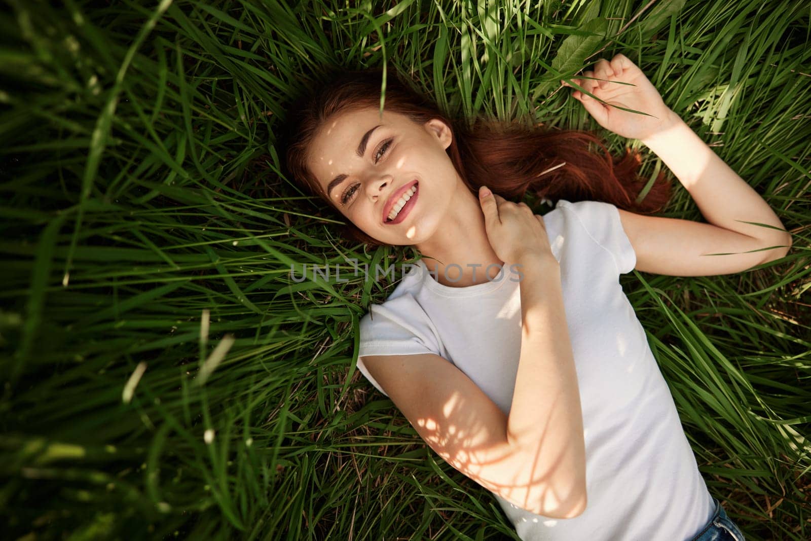 woman basking in the sun lying in tall grass. High quality photo