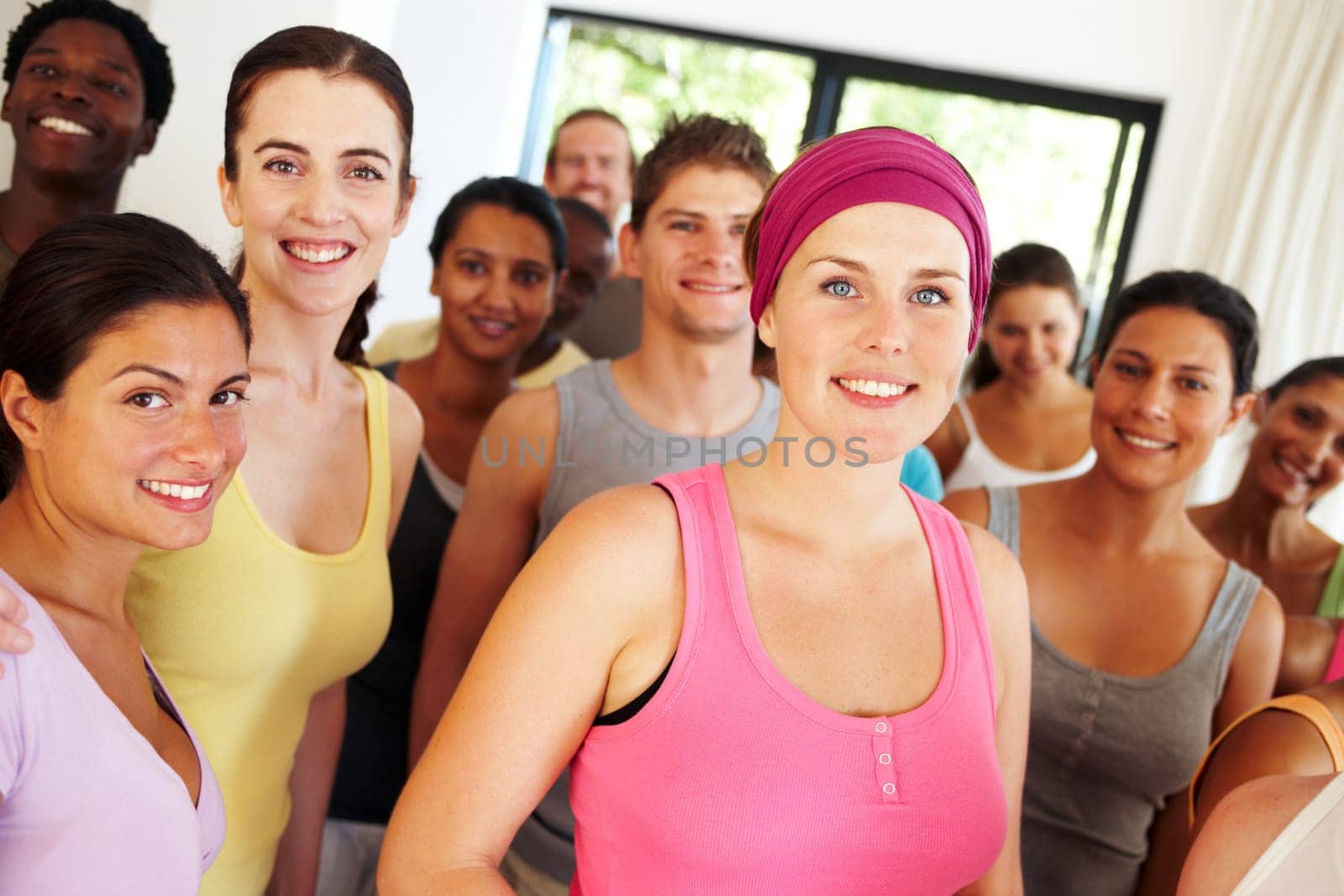 Keeping in shape keeps them happy. Portrait of a a group of yoga enthusiasts standing in a yoga studio. by YuriArcurs