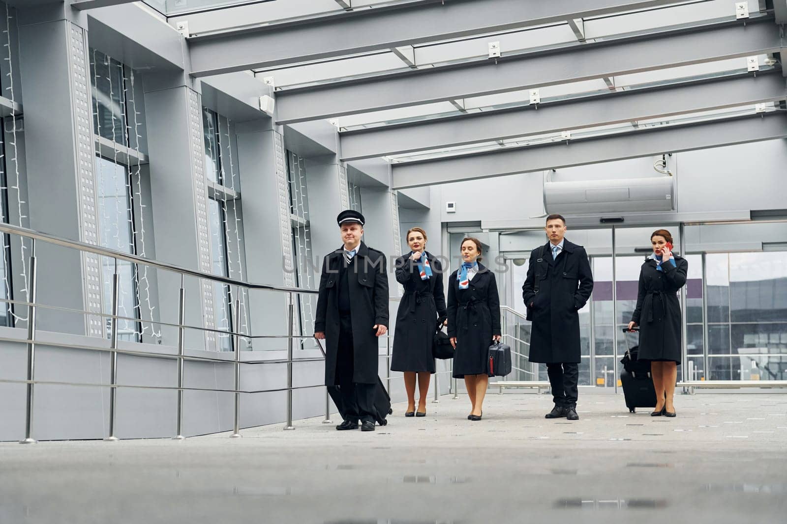 In uniform. Airplane crew in uniform is going to the work together by Standret