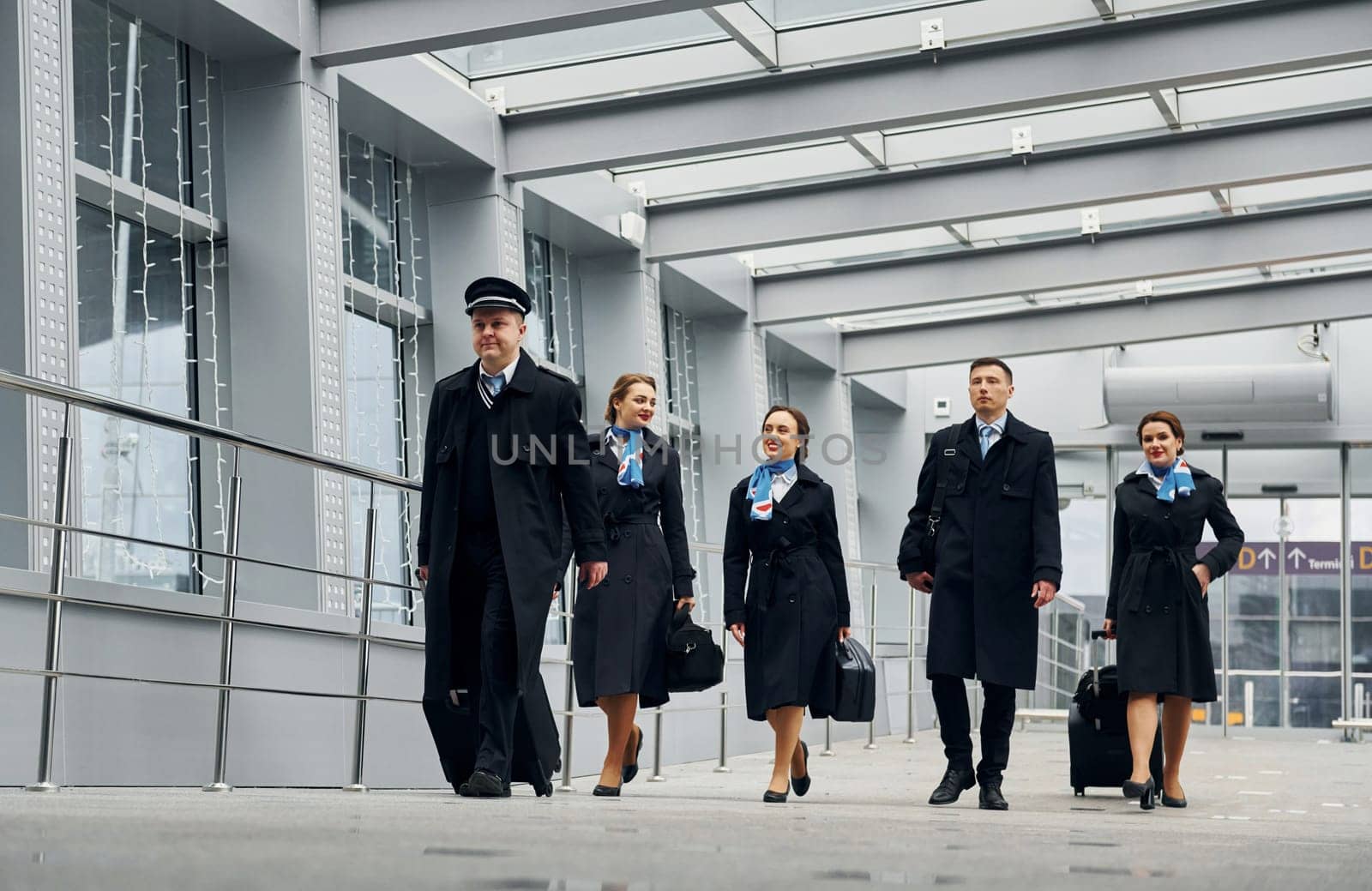 In uniform. Airplane crew in uniform is going to the work together by Standret