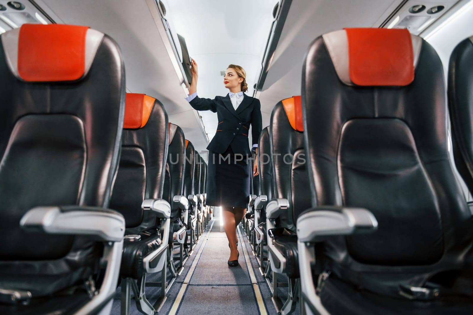 Empty seats. Young stewardess on the work in the passanger airplane.