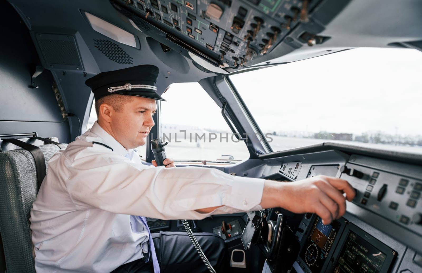 Control of the flight. Pilot on the work in the passenger airplane. Preparing for takeoff by Standret