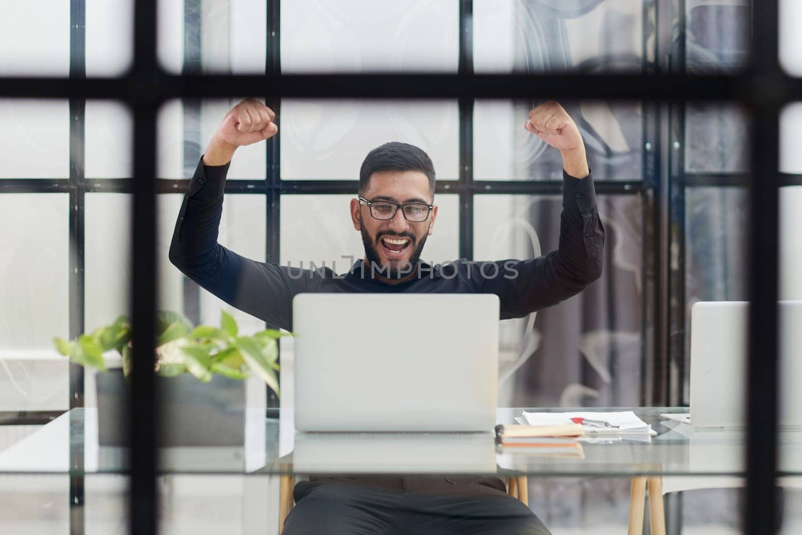 Business man sitting at his desk in the office with a laptop