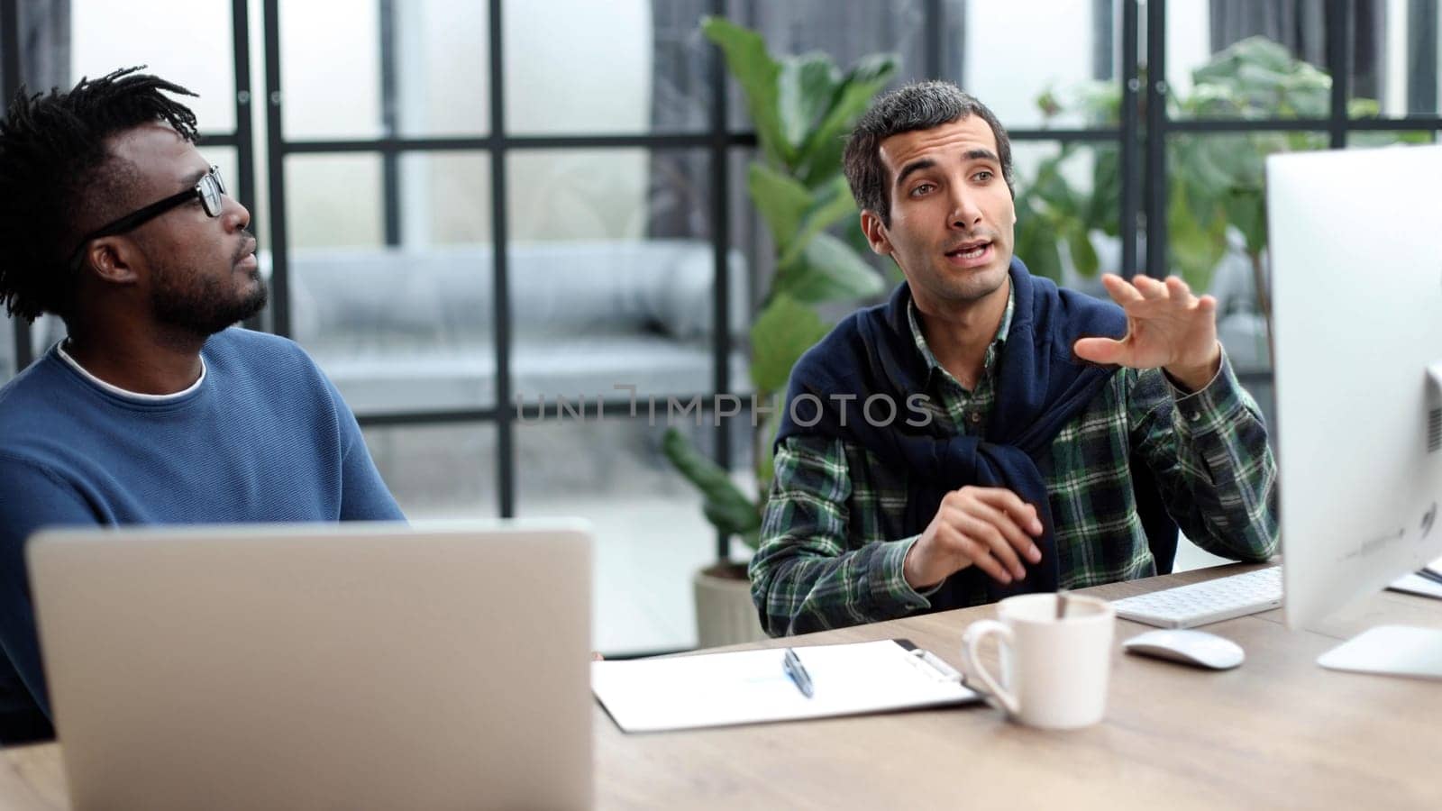 Business people working together in a modern trendy office behind a laptop