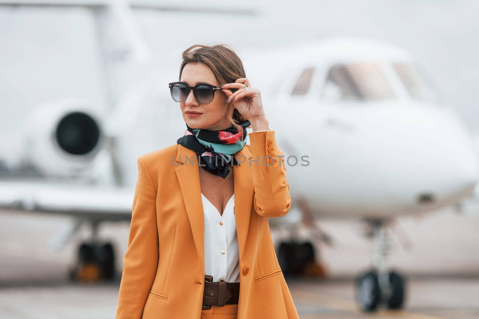 Conception of tourism. Passenger woman that is in yellow clothes and sunglasses by Standret