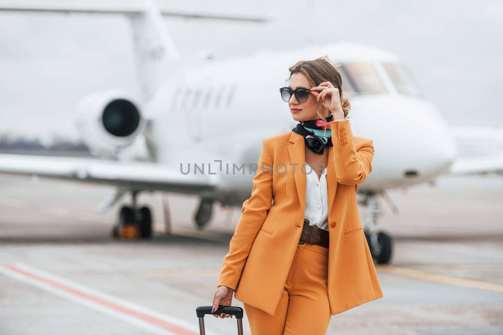 Conception of tourism. Passenger woman that is in yellow clothes and sunglasses by Standret