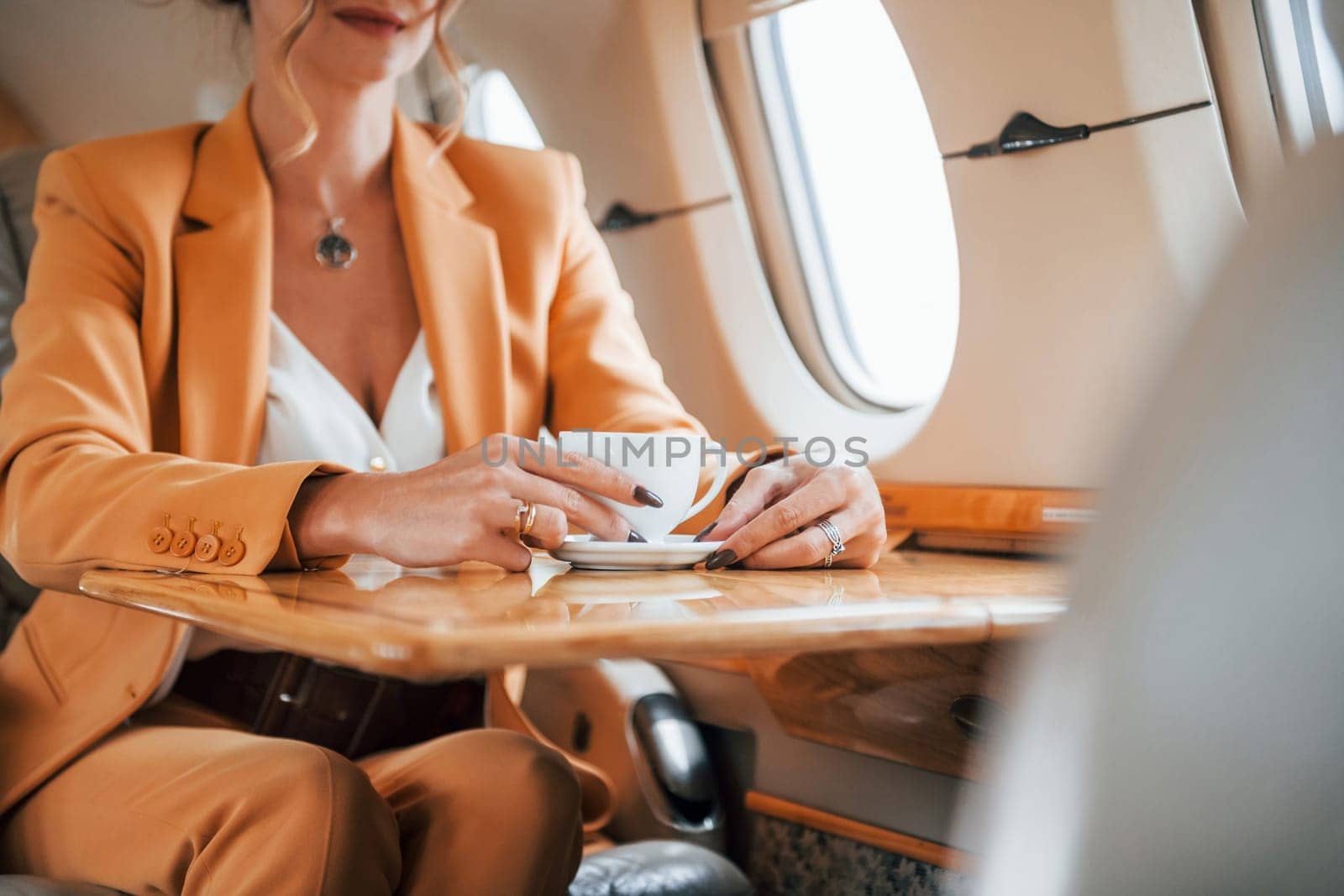 Young passenger woman in yellow clothes is flying in the plane.