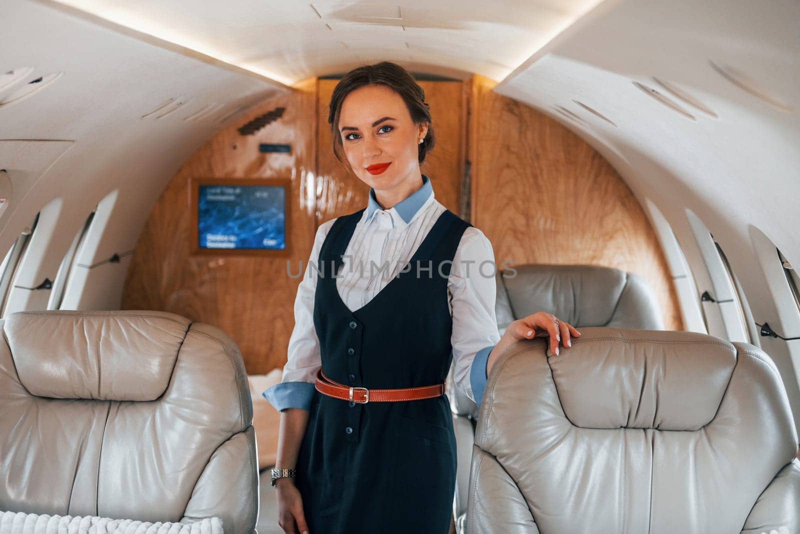 Young stewardess on the work in the passanger airplane.