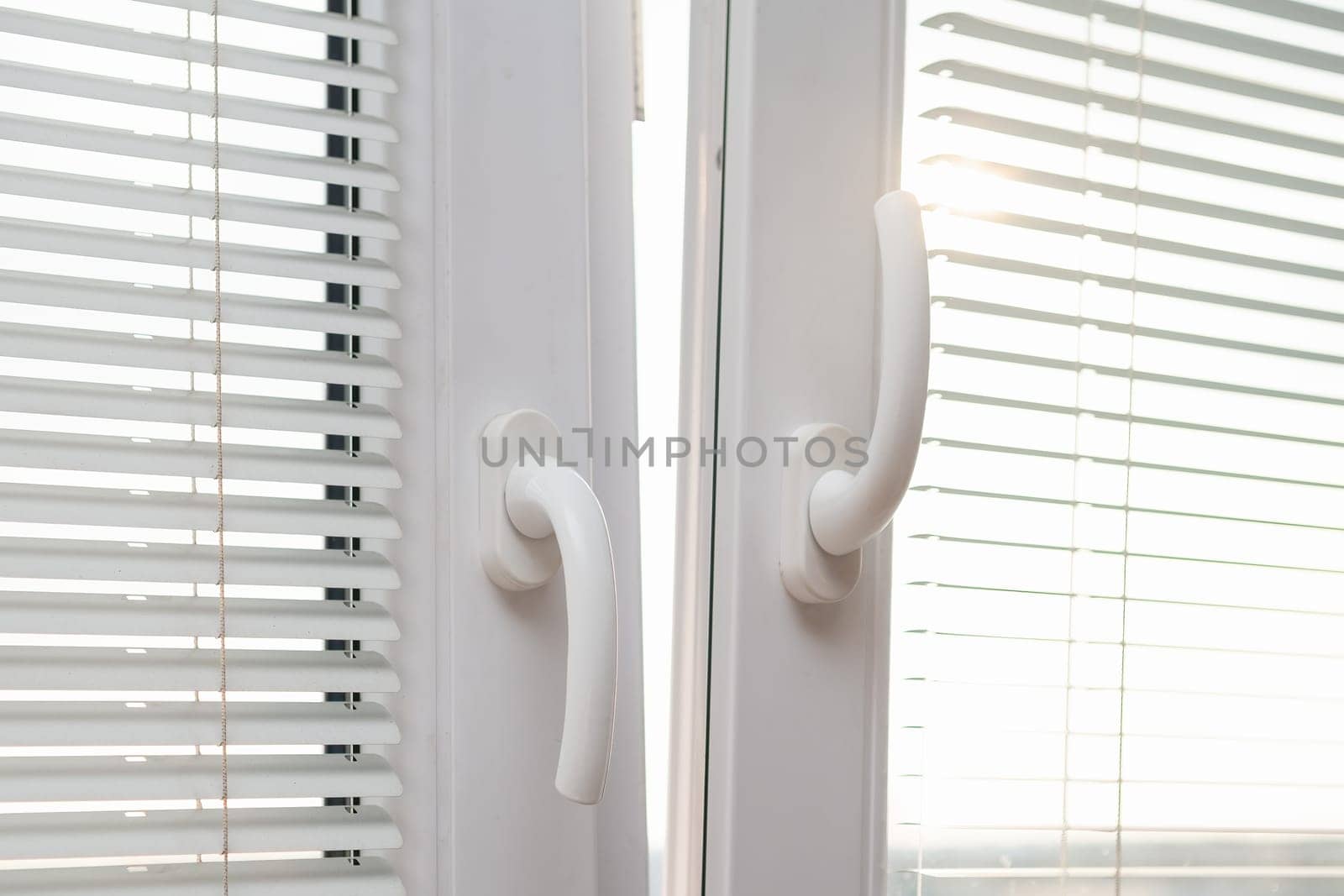 Open plastic window for ventilation. Handle up and down. PVC metal blinds on the window frame.