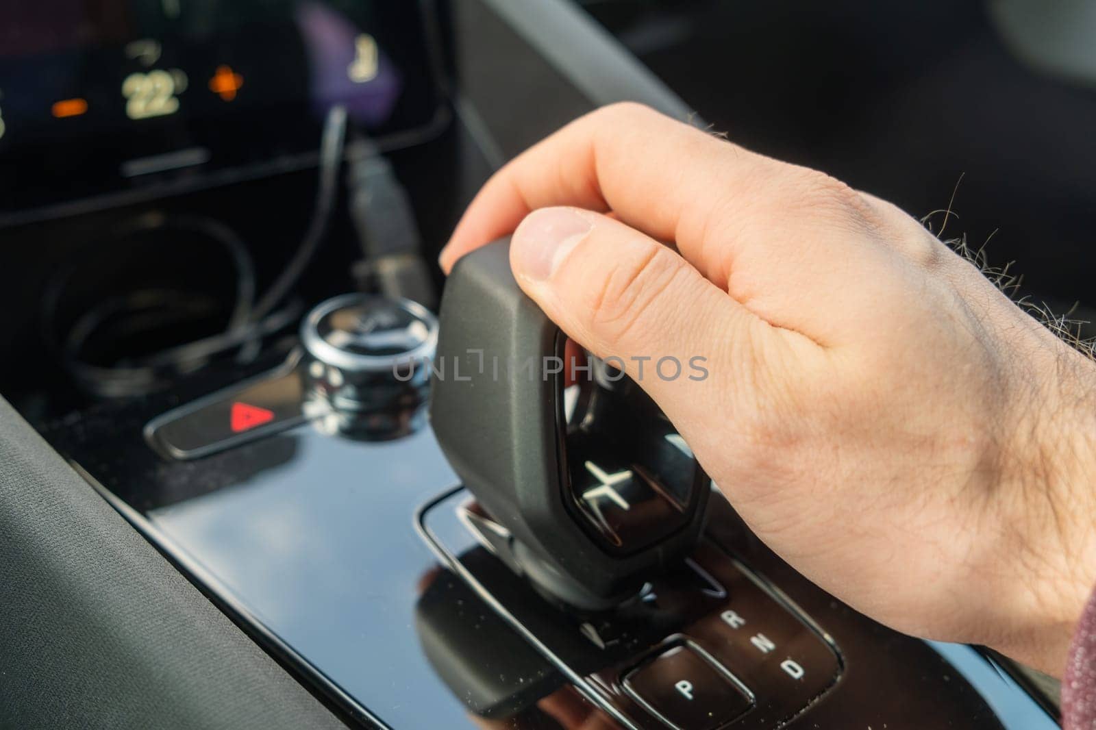 PRAGUE , CZECH REPUBLIC - MARCH 10 2022: Man shifts mode on automatic transmission of new electric car Polestar 2. Luxury modern automobile with stylish interior design closeup