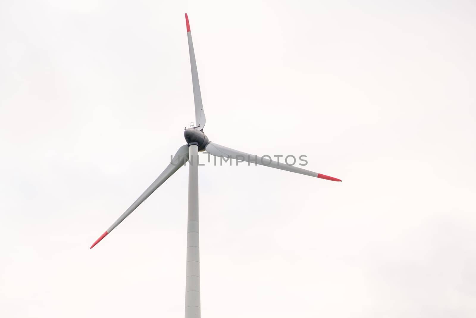 Windmill propeller against the grey sky. Generation of green energy.