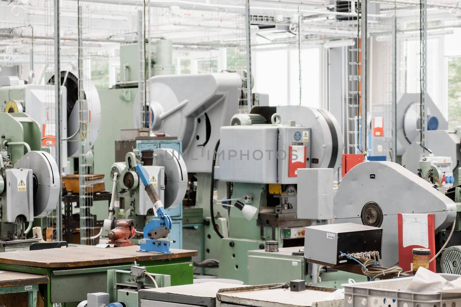 Different contemporary automated machine tools installed to process material and produce goods in light workshop of production plant