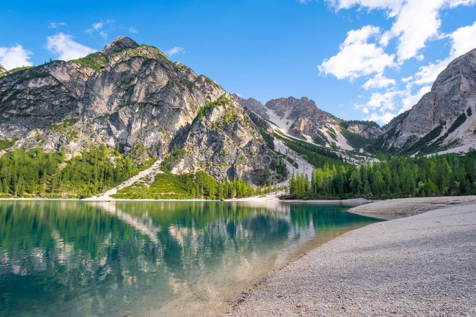 Braies Lake in Dolomites mountains with clouds reflected in the water