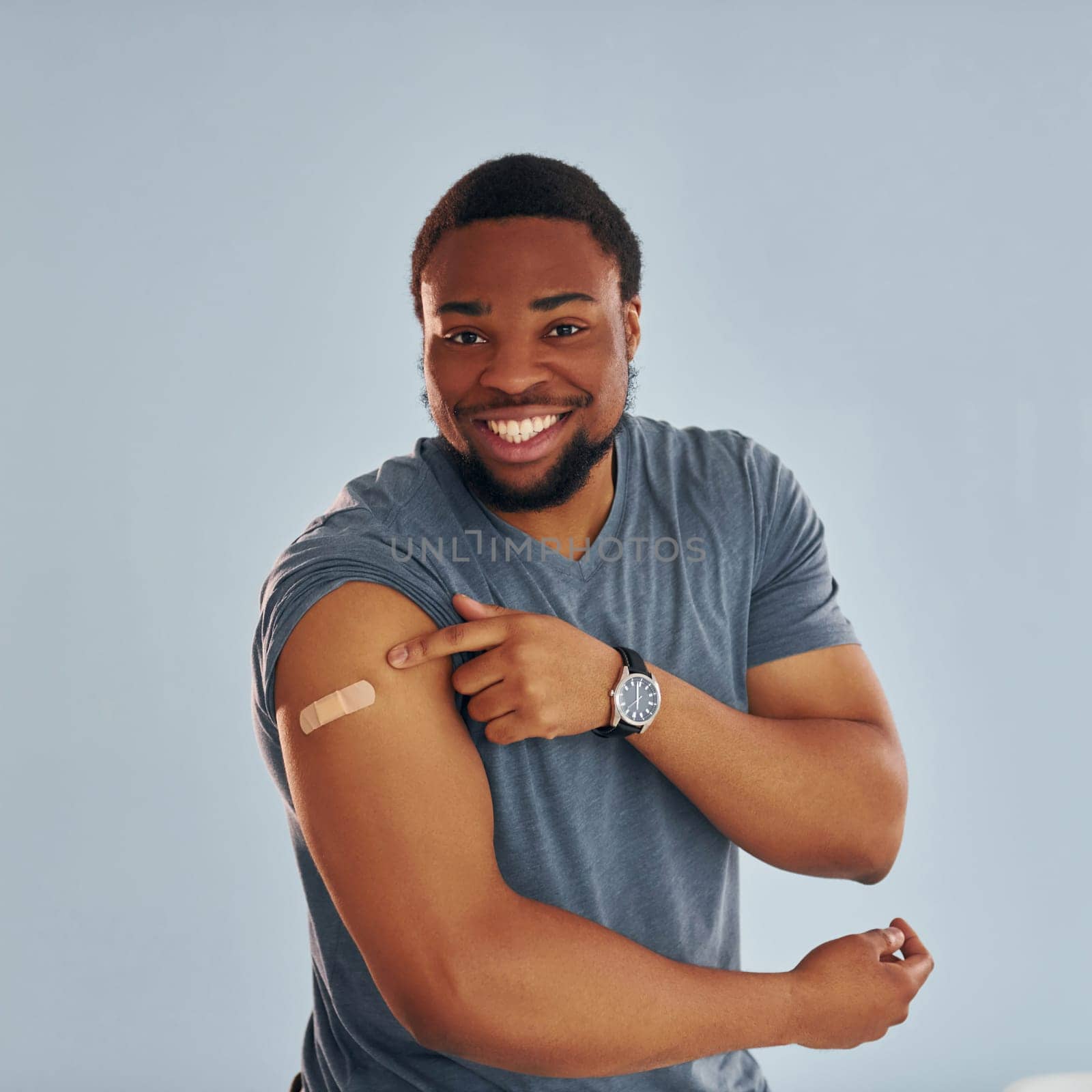 Young african american man after vaccine injection is indoors.