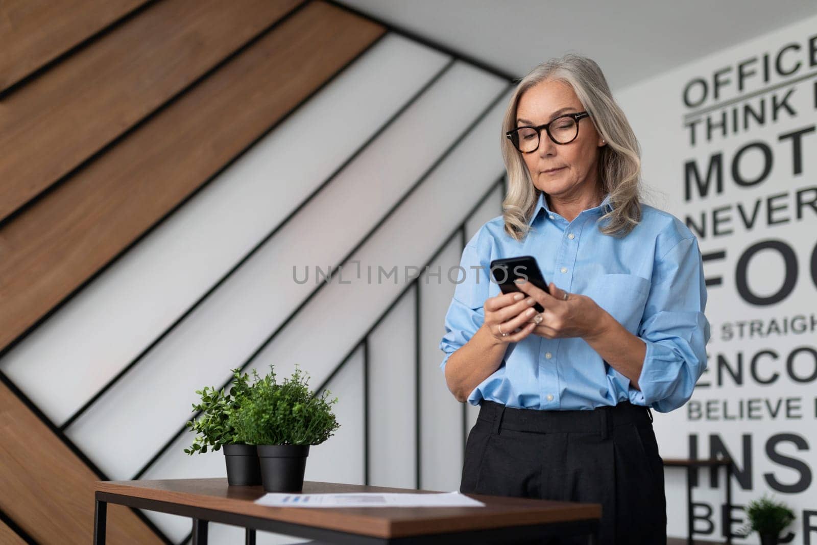 caucasian woman office manager with mobile phone in hands.