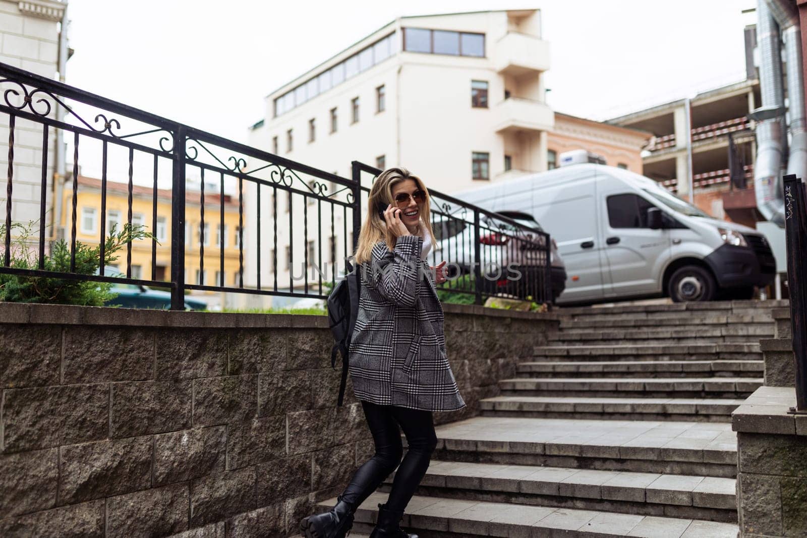 a woman climbs the stairs speaks on a mobile phone and turns around.