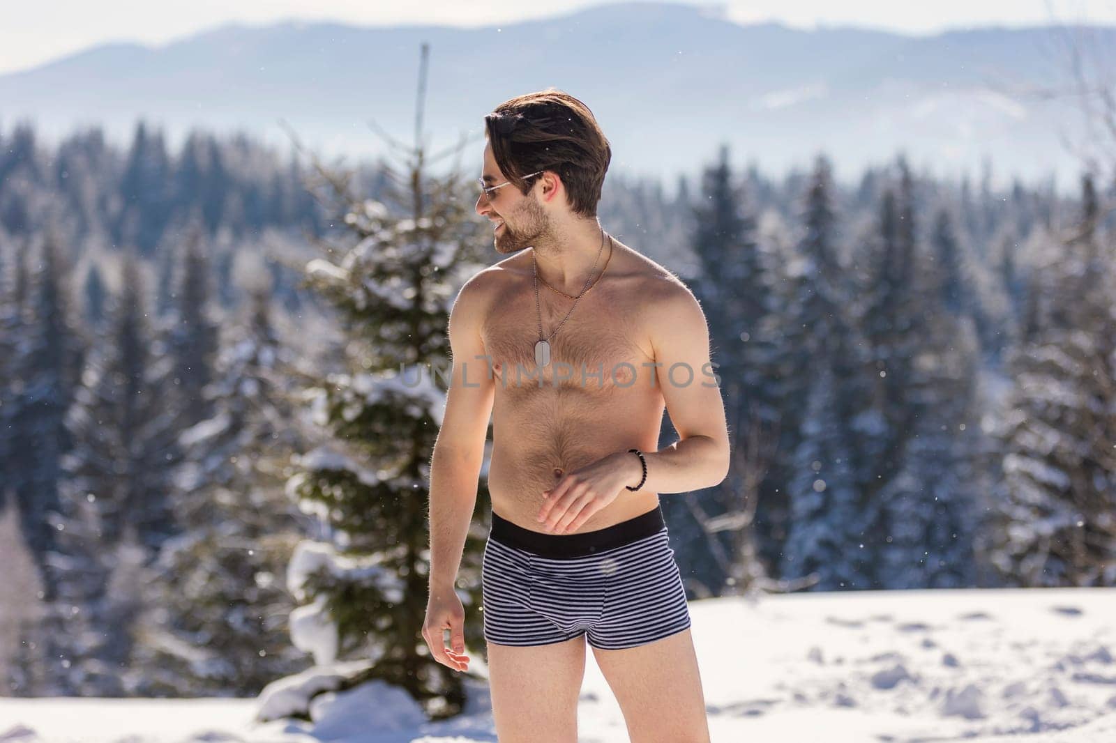 man in shorts and sunglasses on the background of snow-capped mountains