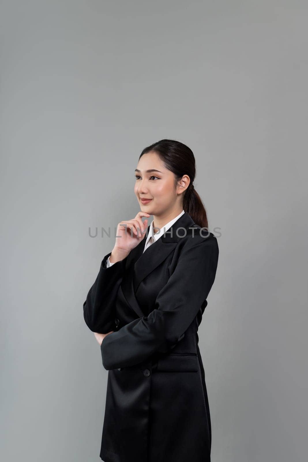 Confident young businesswoman stands on isolated background. Enthusiastic by biancoblue