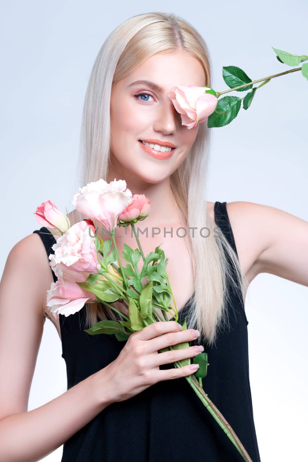 Closeup young personable woman with flawless makeup holding flower. by biancoblue