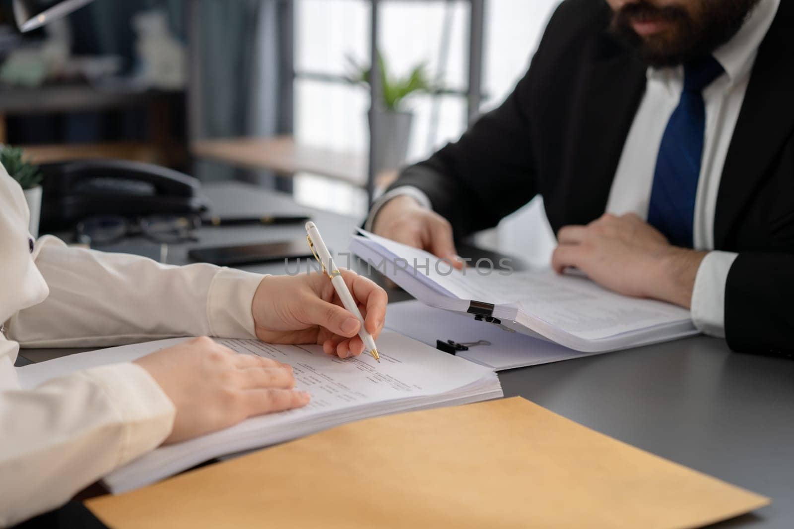 Businesspeople working in the office on official corporate papers, office workers reviewing stack of financial documents and working on business report. Equilibrium