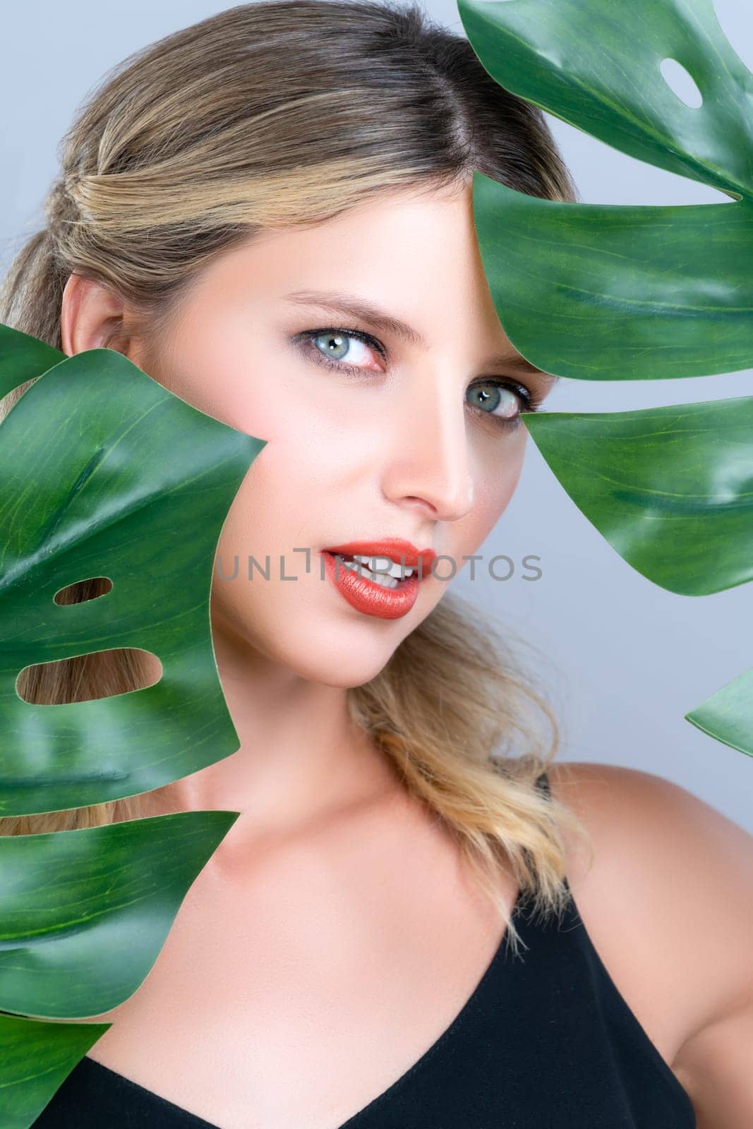 Closeup woman with alluring perfect clean skin holding green leave. by biancoblue