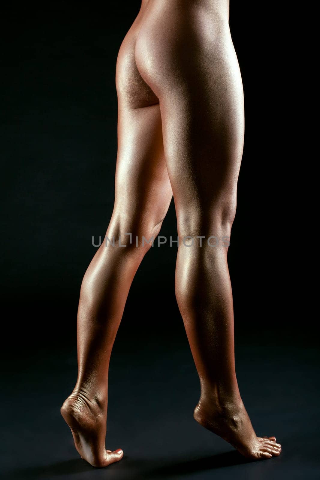 Slender female legs like bronze statue, close-up