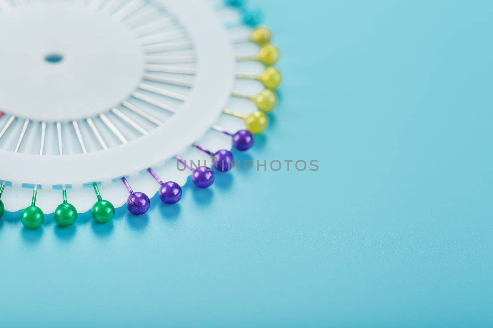 Sewing mother-of-pearl pins in a round white package by AlexGrec