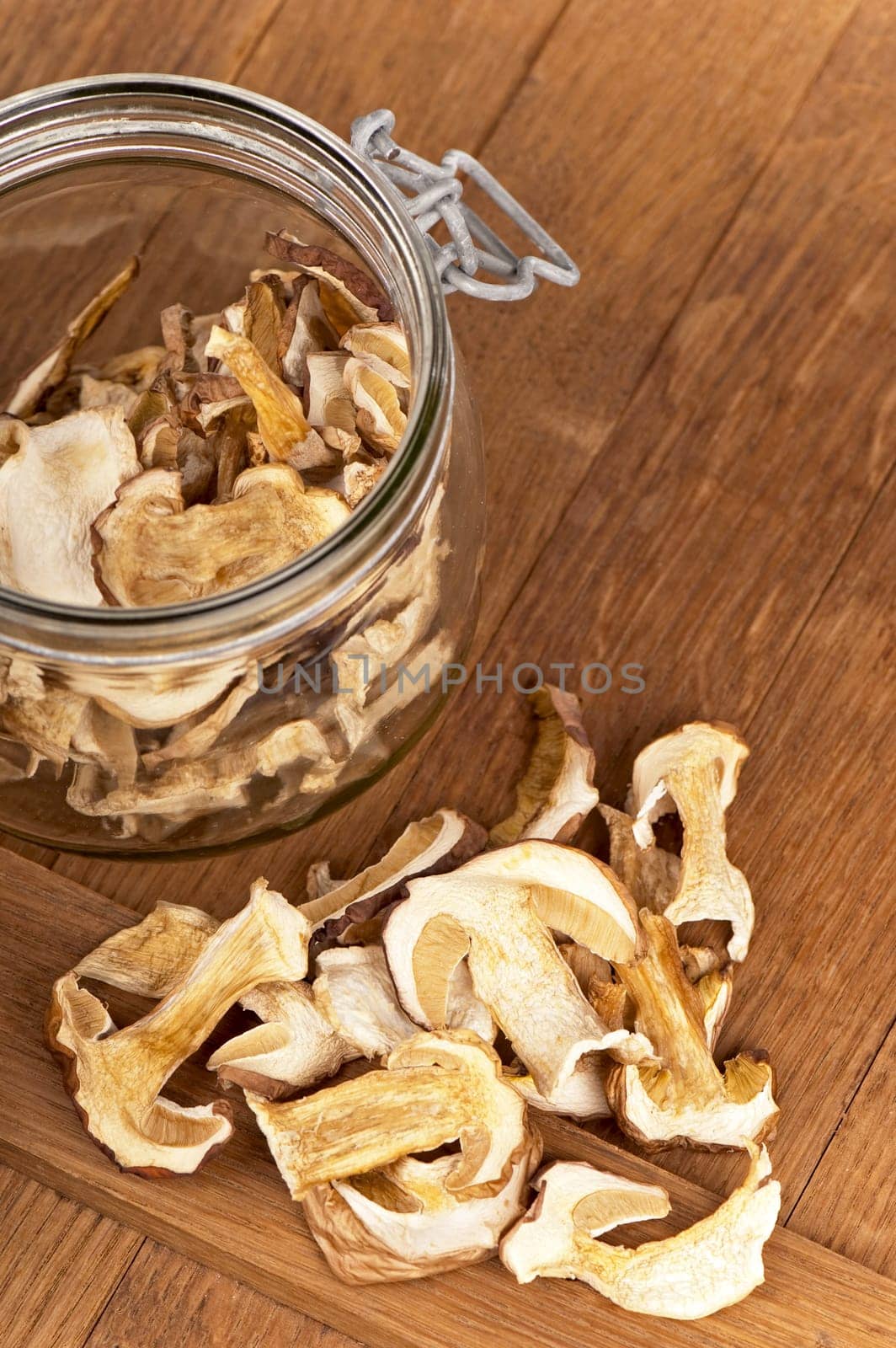 Porcini mushrooms cut into slices and dried are used to prepare vegetarian dishes. Dried Porcini Mushrooms On A Wooden Kitchen Table by aprilphoto