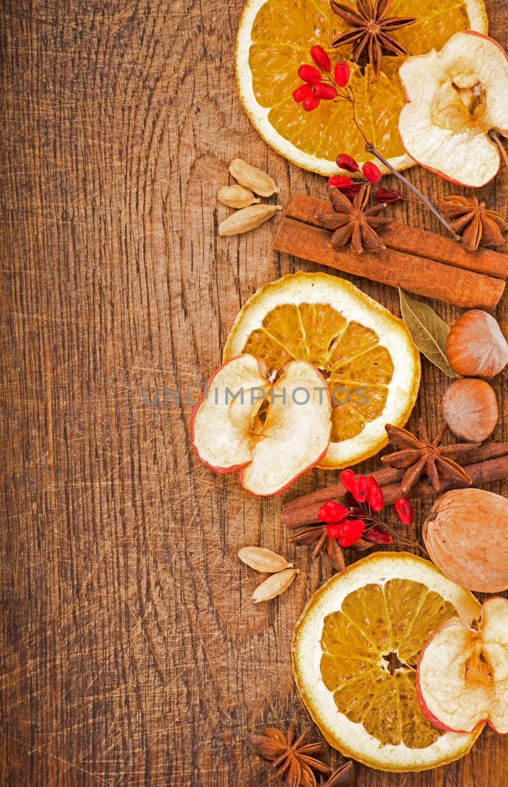 Christmas frame. Spices and dried orange sliceson on a wooden table by aprilphoto