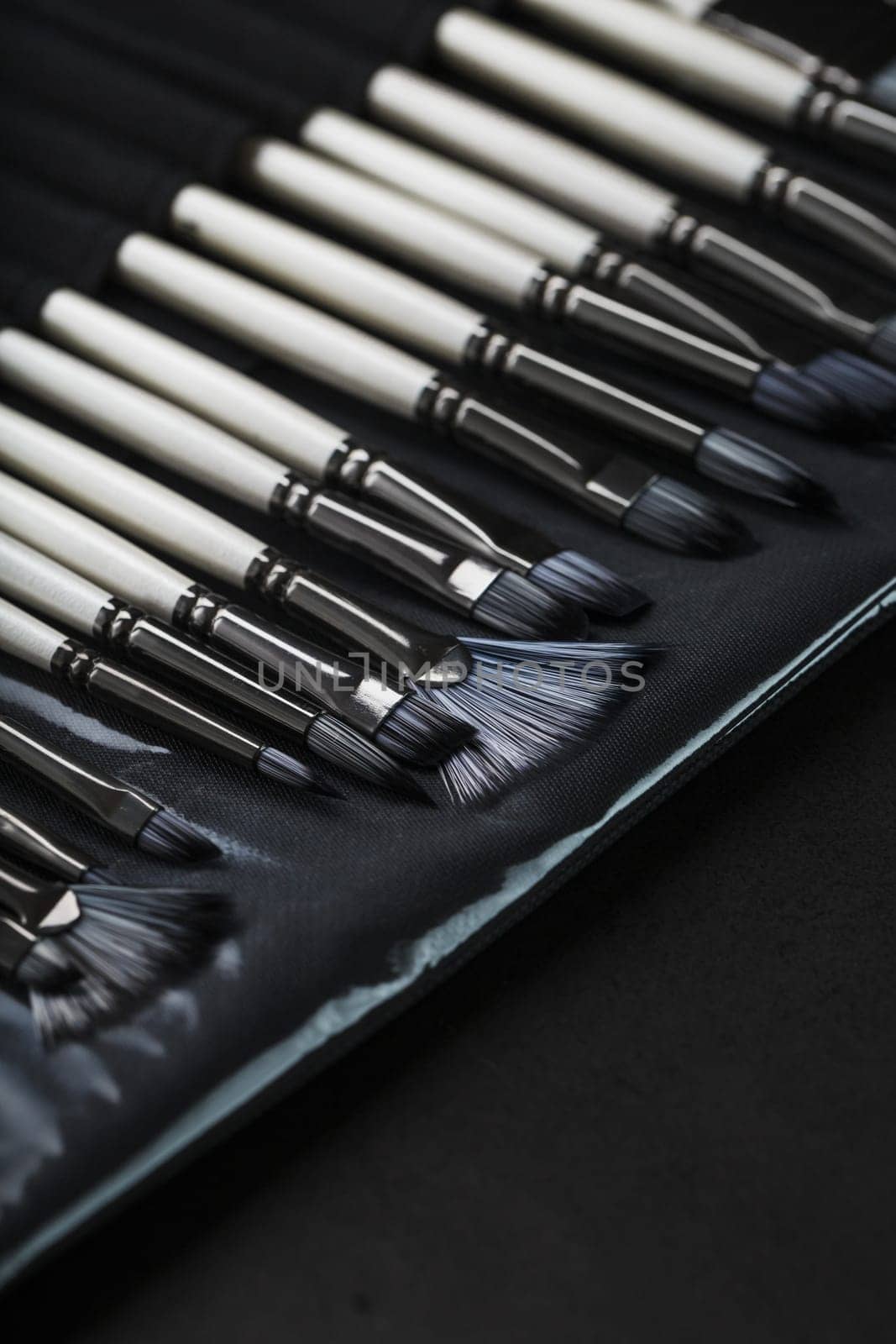 A set of oil brushes and palette knife isolated on a black background, Close-up