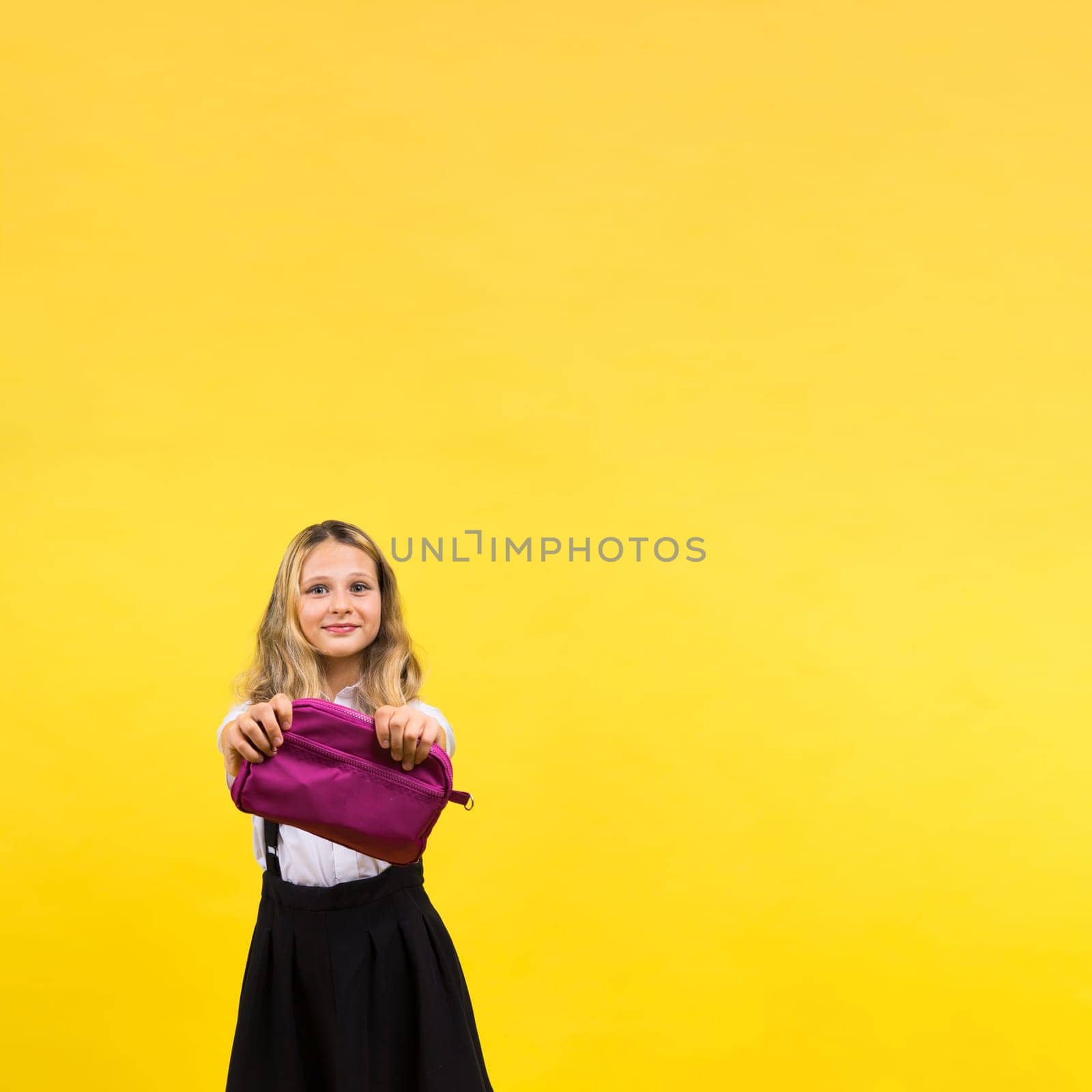 Little teenager girl with pencil case on yellow background by Zelenin