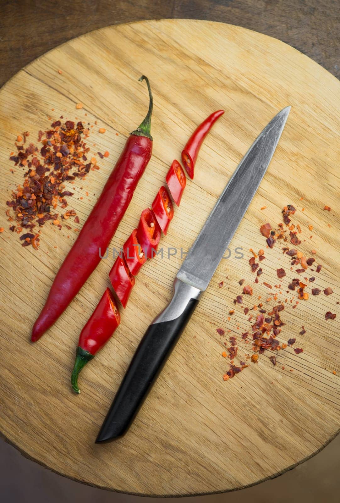 Red chili pepper cut into pieces on a black background. Hot spice, red chili and chili powder. by aprilphoto