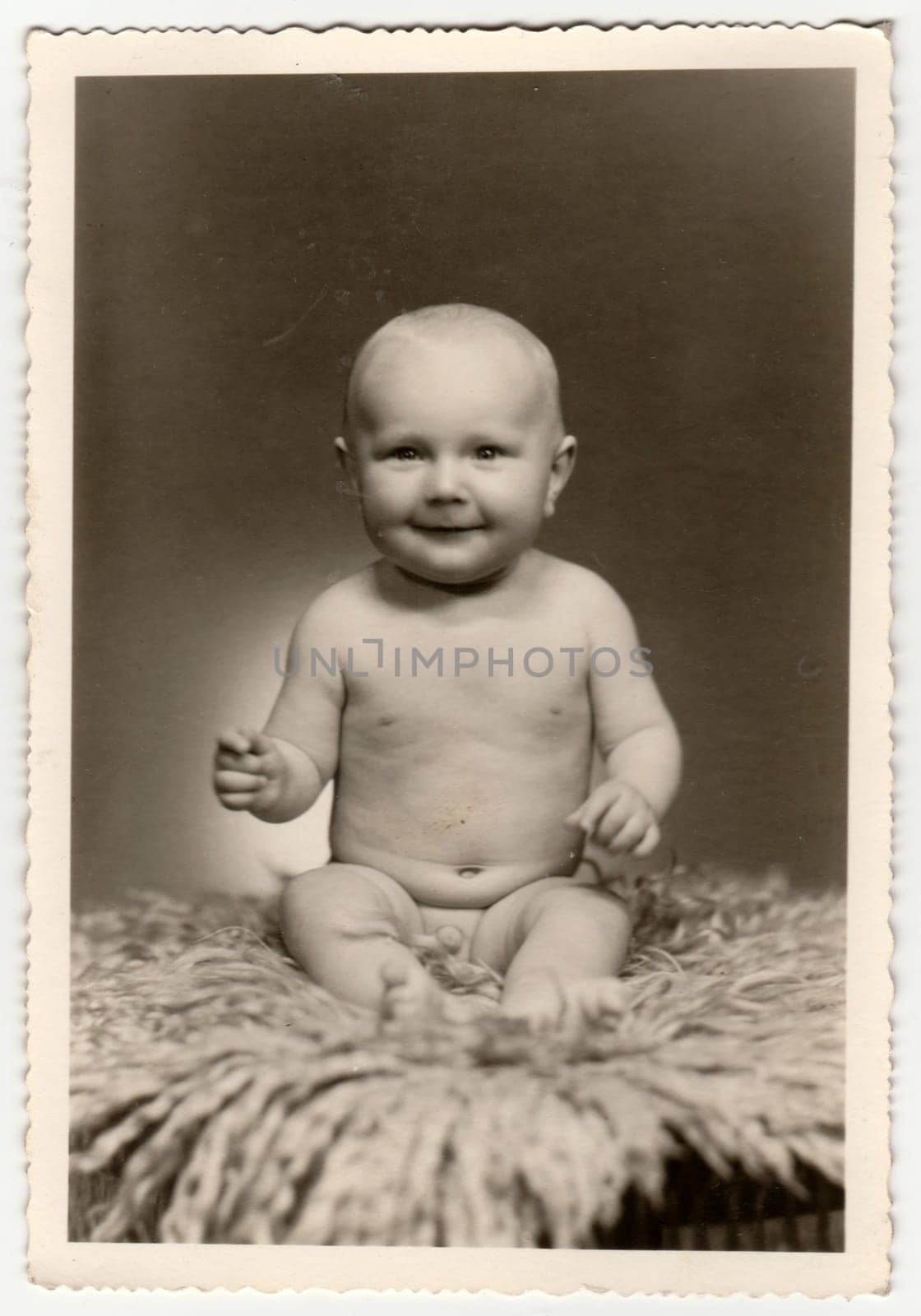 Vintage photo shows a cute naked baby boy. Retro black and white photography. Circa 1960. by roman_nerud