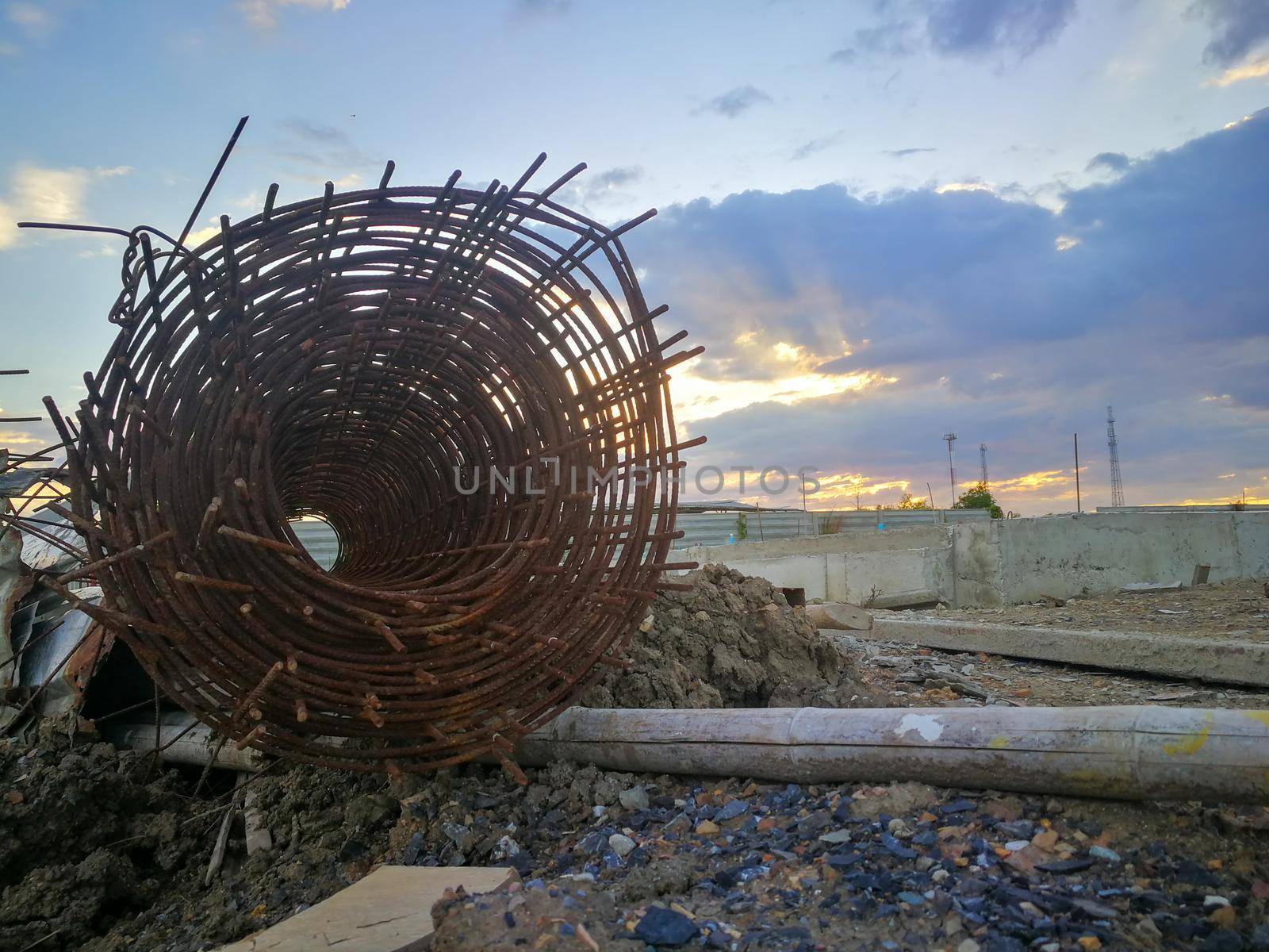 Rusted steel rolls in construction projects. Steel and bamboo on clay and stone piles