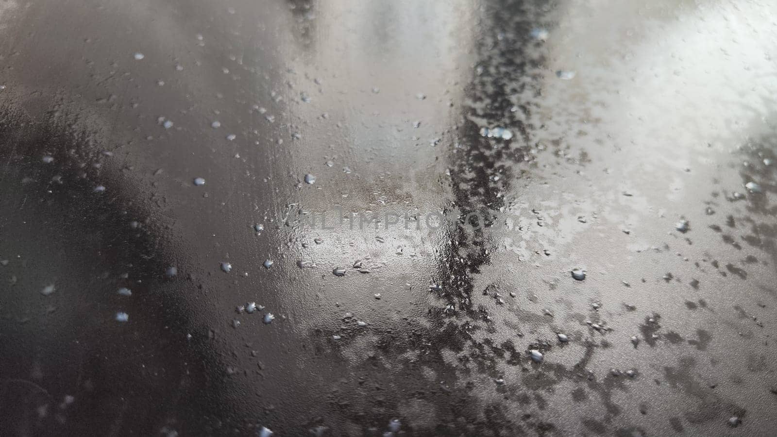 Water drops on black plastic. Surface with wet background. Abstract texture and pattern full of water. Raindrops of rain for overlaying on window with partial focus. Concept of autumn weather