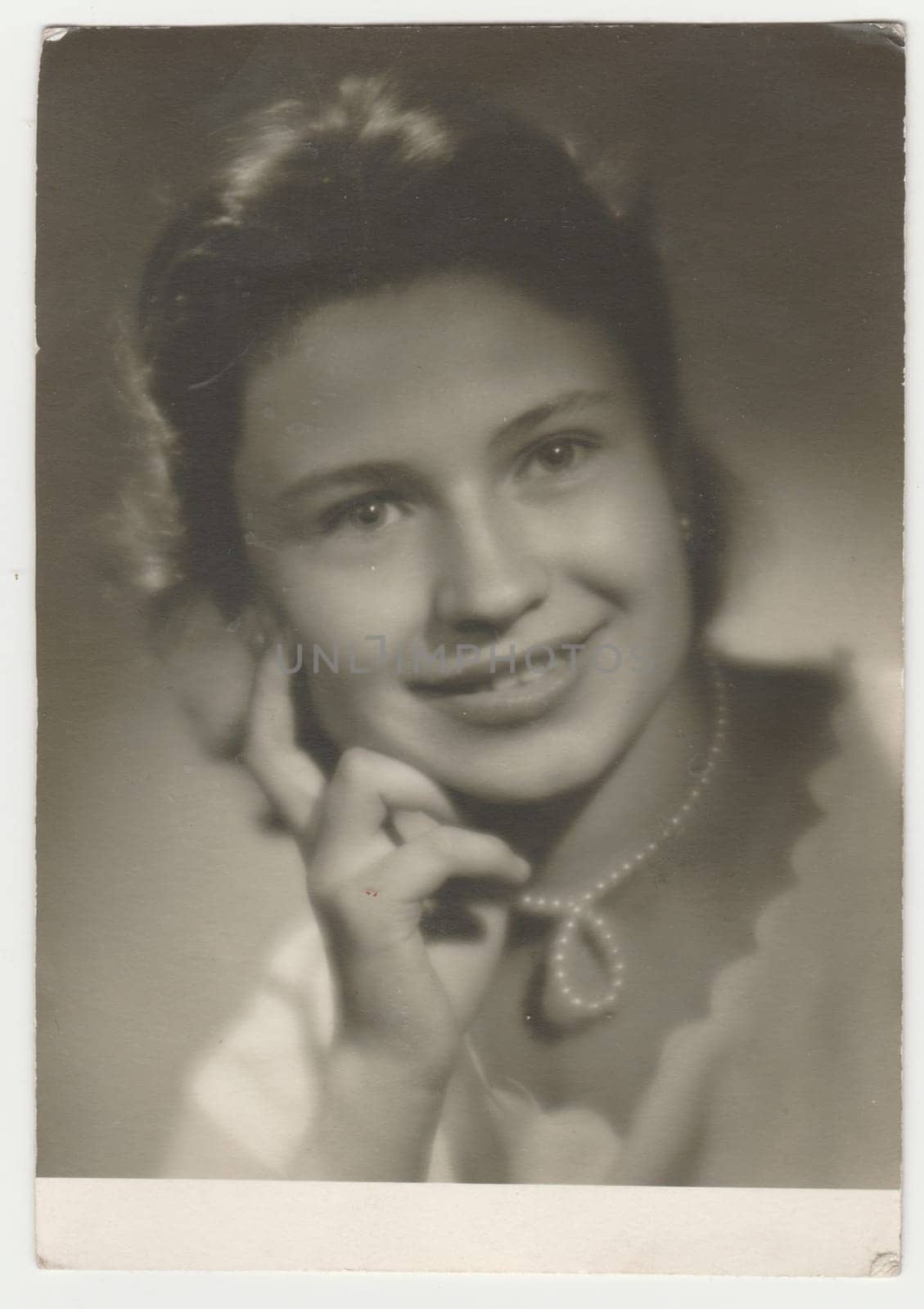 Vintage photo shows a teenager girl poses in the photography studio. Photo with blurred tint. Retro black and white photography. Circa 1960. by roman_nerud