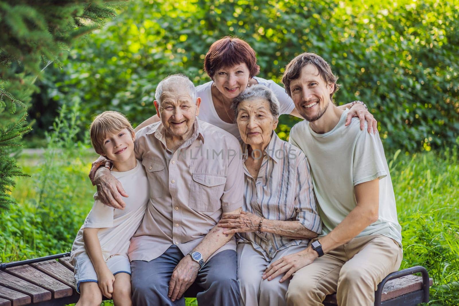 Four generations of family spend time together in the park. Elderly couple. Senior husband and wife holding hands and bonding with true emotions by galitskaya
